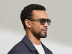 Model is wearing The MINYAN SUN in size 54 in Dark Green with Forest Wood Tinted Lenses