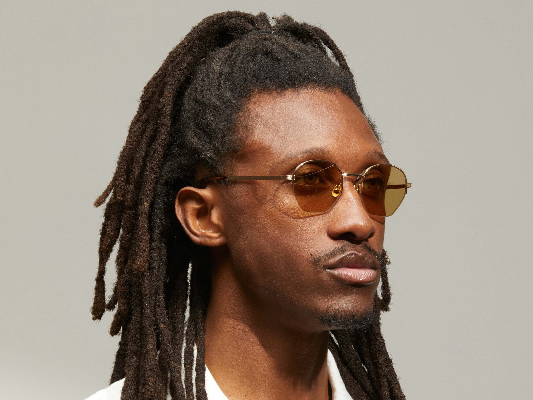 Model is wearing The PLOTZ SUN in size 49 in Gold with Amber Tinted Lenses