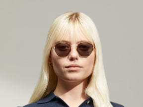 Model is wearing The PLOTZ SUN in size 49 in Gold with G-15 Tinted Lenses