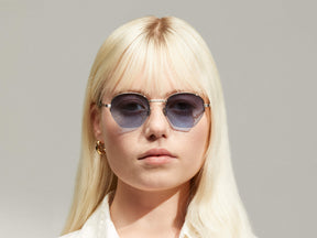 Model is wearing The PLOTZ SUN in size 49 in Silver with Denim Blue Tinted Lenses