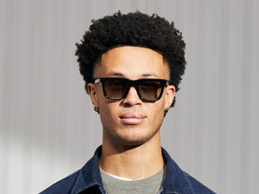 Model is wearing The RIZIK in Black in size 49 with Forest Wood Tinted Lenses