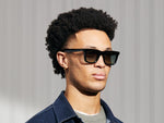 Model is wearing The RIZIK in Black in size 49 with Forest Wood Tinted Lenses