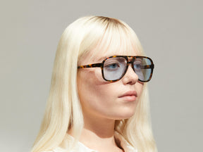 Model is wearing The SHEISTER SUN in Tortoise in size 57 with Bel Air Blue Tinted Lenses