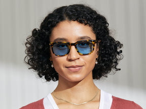 Model is wearing The SHIDDOCK SUN in Tokyo Tortoise in size 52 with Celebrity Blue Tinted Lenses