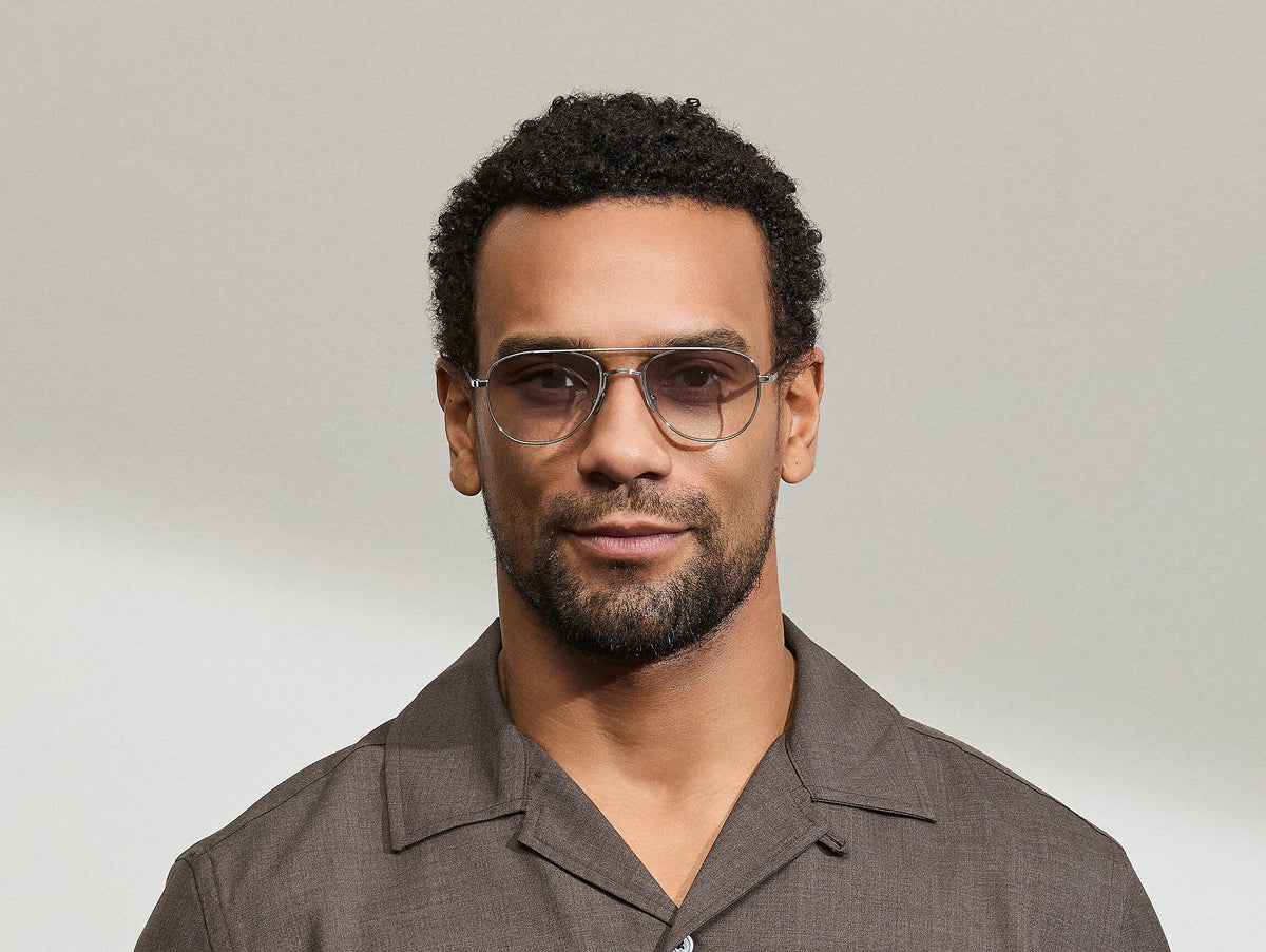Model is wearing The SHMECKEL SUN in size 53 in Silver with American Grey Fade Tinted Lenses