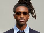 Model is wearing The SHTARKER SUN in Gold in size 57 with Cosmitan Brown Lenses