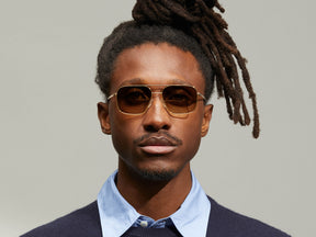 Model is wearing The SHTARKER SUN in Gold in size 57 with Cosmitan Brown Lenses