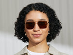 Model is wearing The SHTARKER SUN in Gold in size 57 with Cosmitan Brown Lenses
