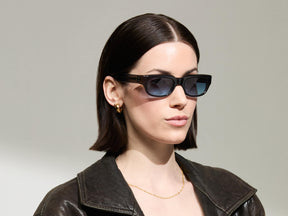 Model is wearing The SHTUP SUN in size 51 in Grey with Denim Blue Tinted Lenses
