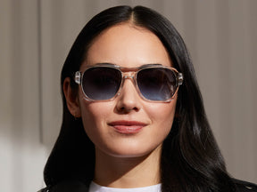 Model is wearing The SHVITZ SUN in Crystal in size 57 with Denim Blue Tinted Lenses