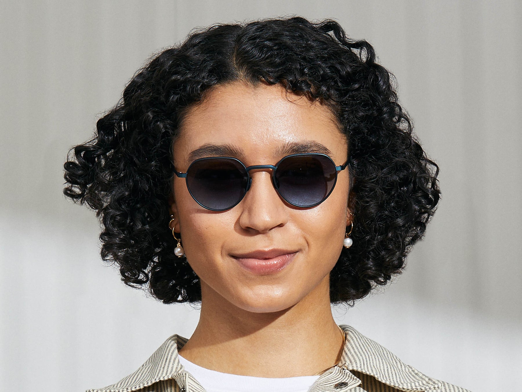 Model is wearing The SMENDRIK SUN in Navy in size 51 with Denim Blue Tinted Lenses