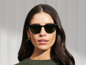 Model is wearing The TATAH SUN in Black in size 50 with G-15 Glass Lenses