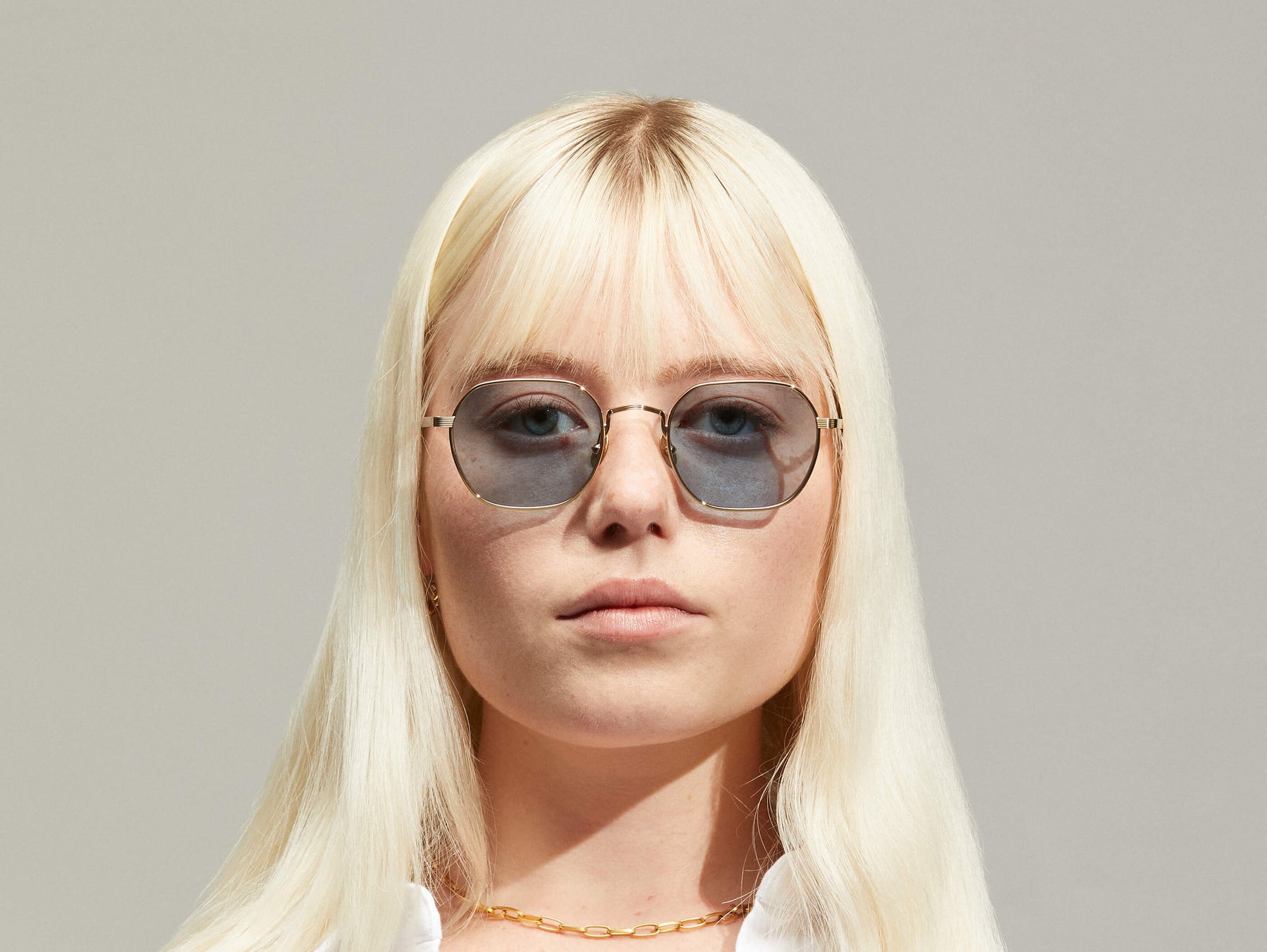 Model is wearing The UTZ SUN in size 50 in Gold with Blue Tinted Lenses
