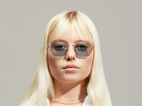 Model is wearing The UTZ SUN in size 50 in Gold with Blue Tinted Lenses