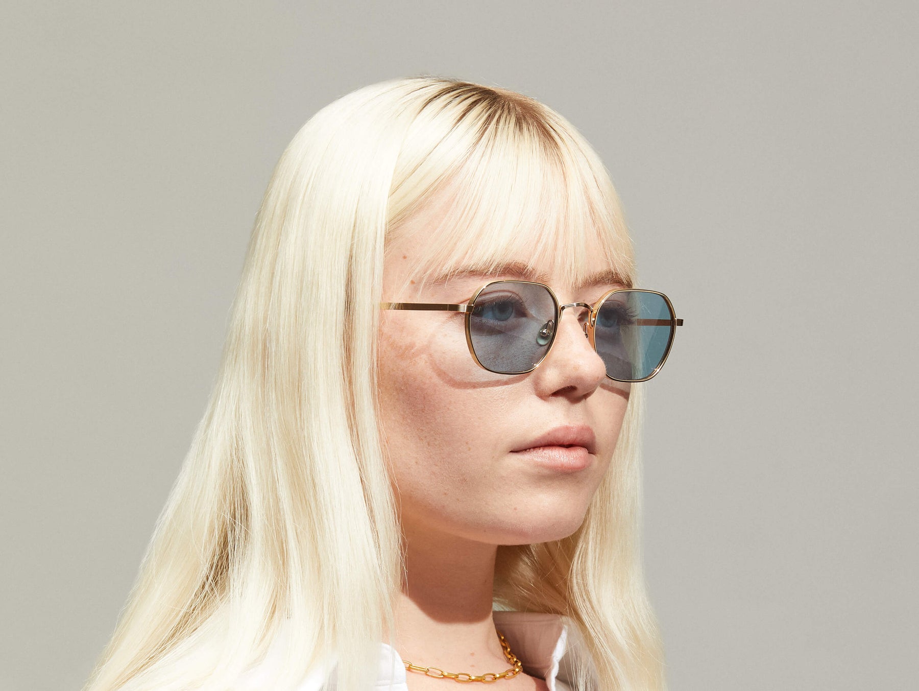 Model is wearing The UTZ SUN in size 50 in Gold with Blue Tinted Lenses