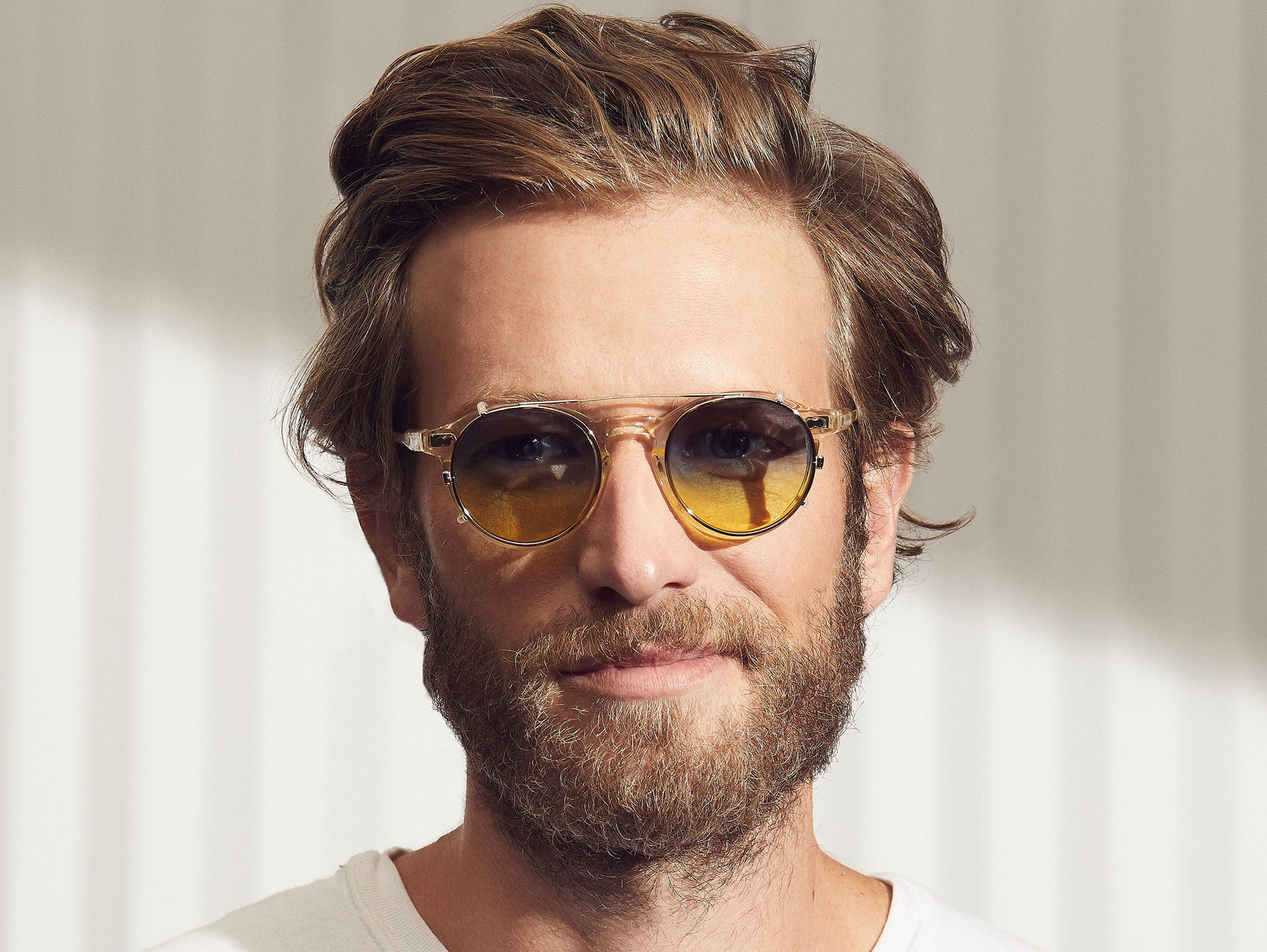 Model is wearing The CLIPZEN in Gold in size 46 with Aqua Sunrise Tinted Lenses