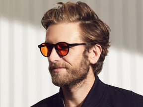 Model is wearing The MILTZEN in Black in size 46 with Woodstock Orange Tinted Lenses