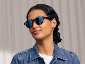 Model is wearing The CLIPTOSH in Gold in size 46 with Blue Mirror Lenses