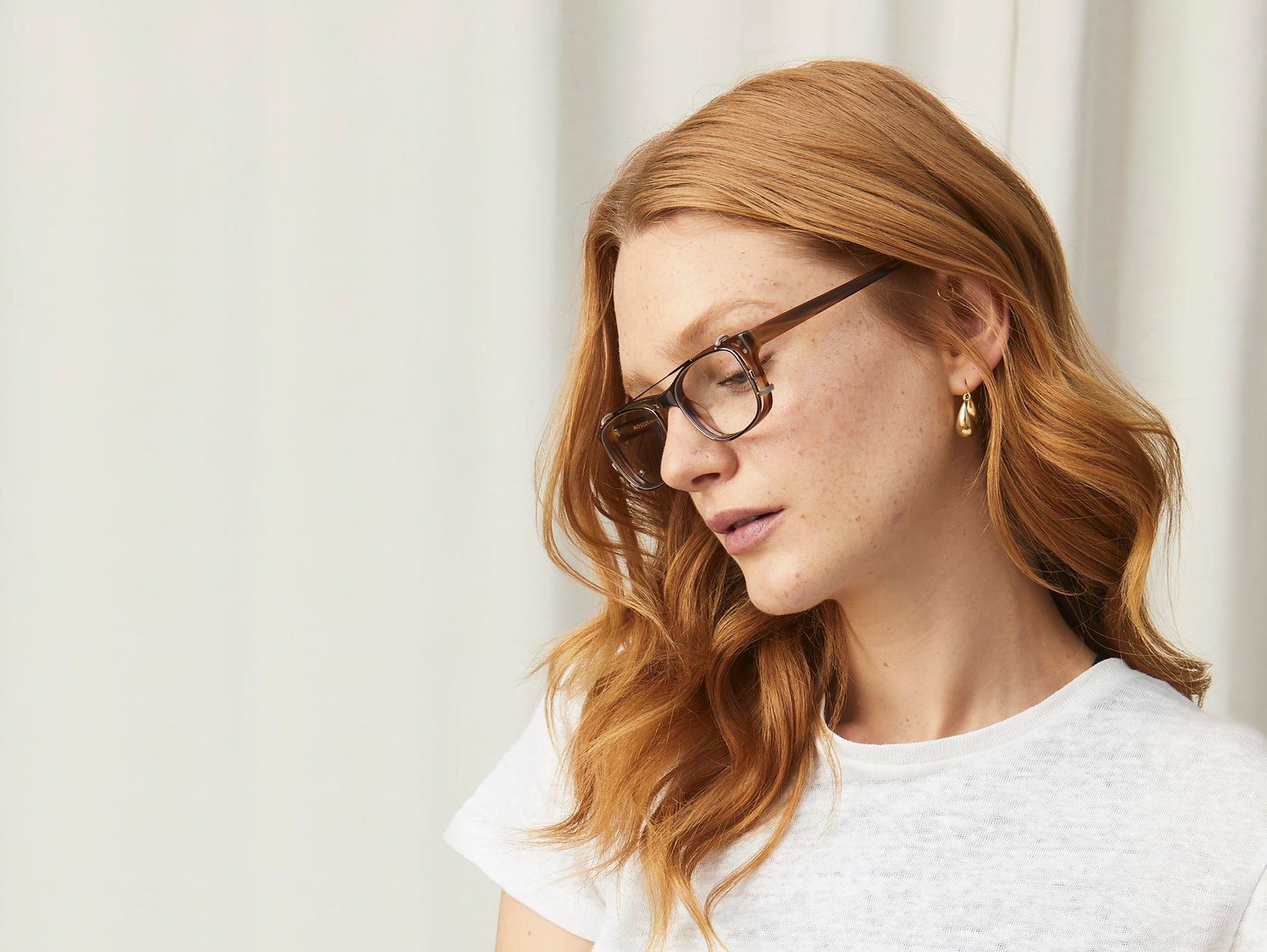 Model is wearing The ALEX CLIP in Brass in size 49 with Blue Protect Lenses