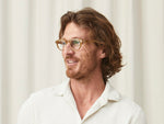 Model is wearing The CLIPTOSH in Gold in size 46 with Blue Protect Lenses