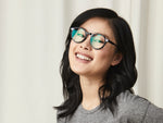 Model is wearing The CLIPZEN in Matte Black in size 49 with Blue Protect Lenses