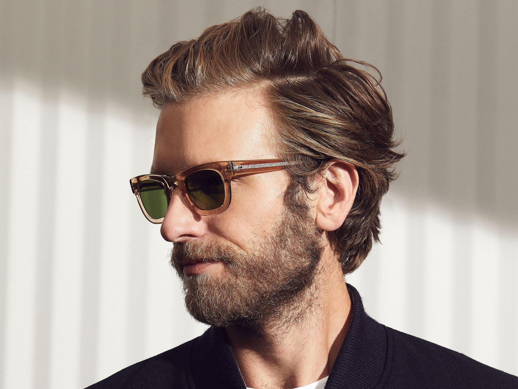Model is wearing the FRITZ SUN in Cinnamon/Flesh in size 44 with Calibar Green Glass Lenses