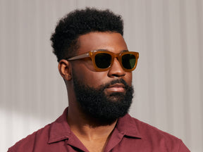 Model is wearing The FRITZ SUN in Butterscotch in size 47 with Calibar Green Glass Lenses