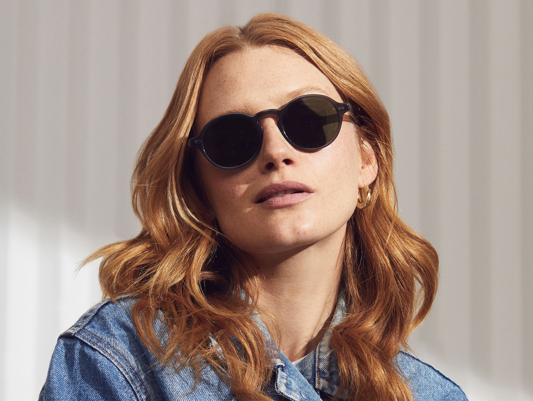 Model is wearing The GLICK SUN in Grey in size 49 with G-15 Glass Lenses