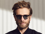 Model is wearing The GOLDA SUN in Spot Tortoise/Gold in size 49 with Blue Glass Lenses