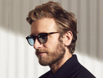 Model is wearing The GOLDA SUN in Spot Tortoise/Gold in size 49 with Blue Glass Lenses