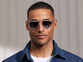 Model is wearing The GOOLAH SUN in Crystal in size 50 with Denim Blue Tinted Lenses