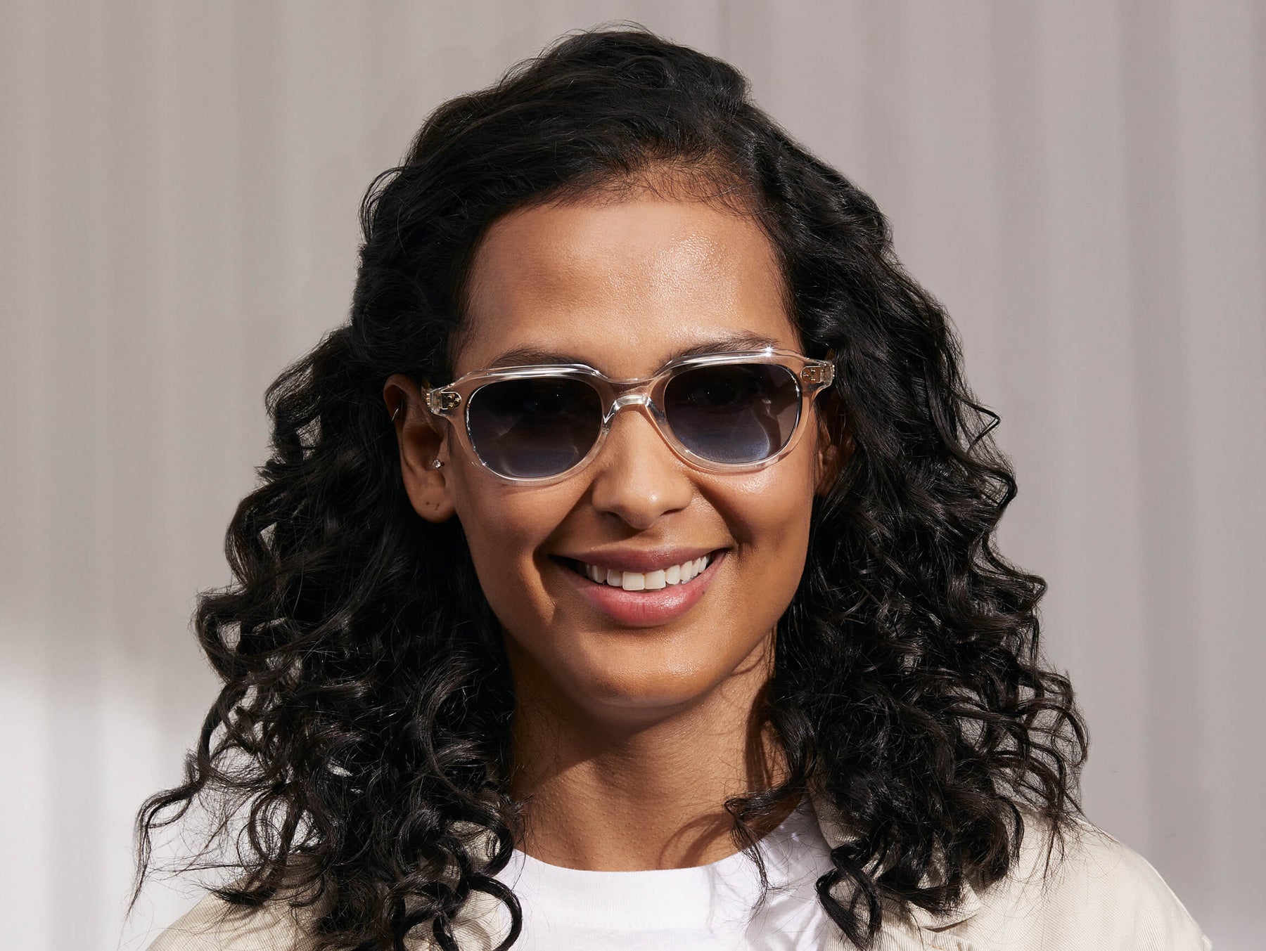 Model is wearing The GOOLAH SUN in Crystal in size 50 with Denim Blue Tinted Lenses