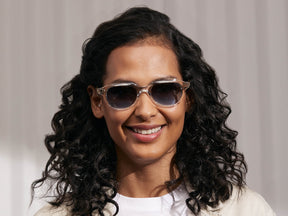 Model is wearing The GOOLAH SUN in Crystal in size 50 with Denim Blue Tinted Lenses