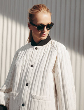 Model is wearing The GRUNYA SUN in Antique Tortoise in size 47 with G-15 Glass Lenses