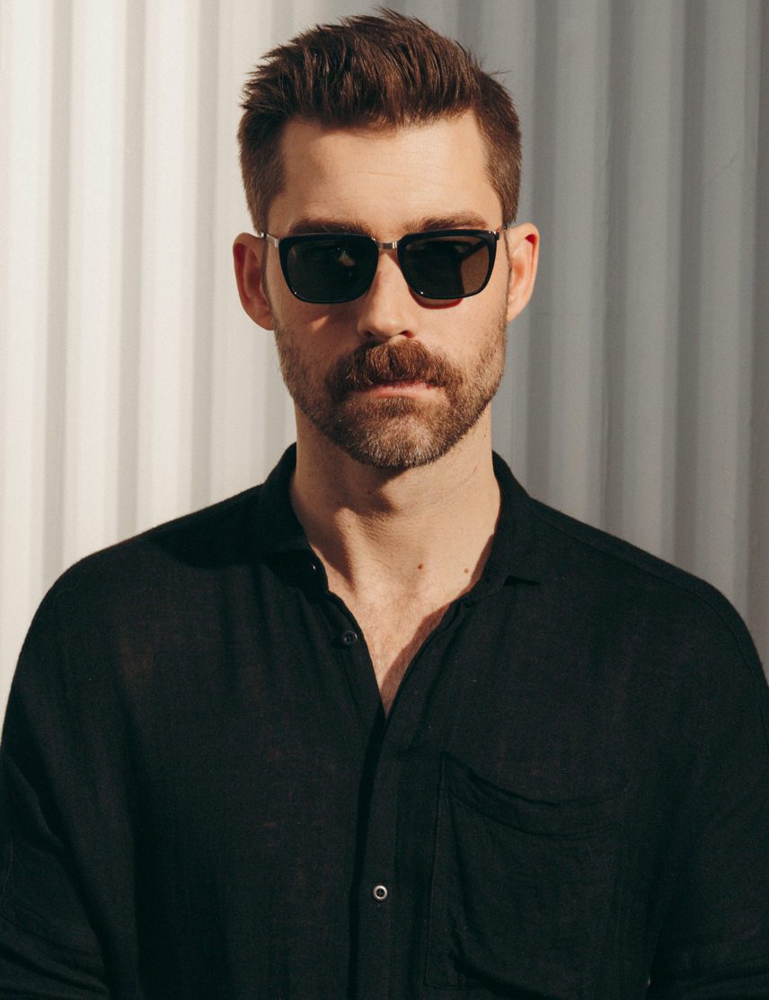 Model is wearing The KLUG SUN in Black/Silver in size 52 with G-15 Glass Lenses