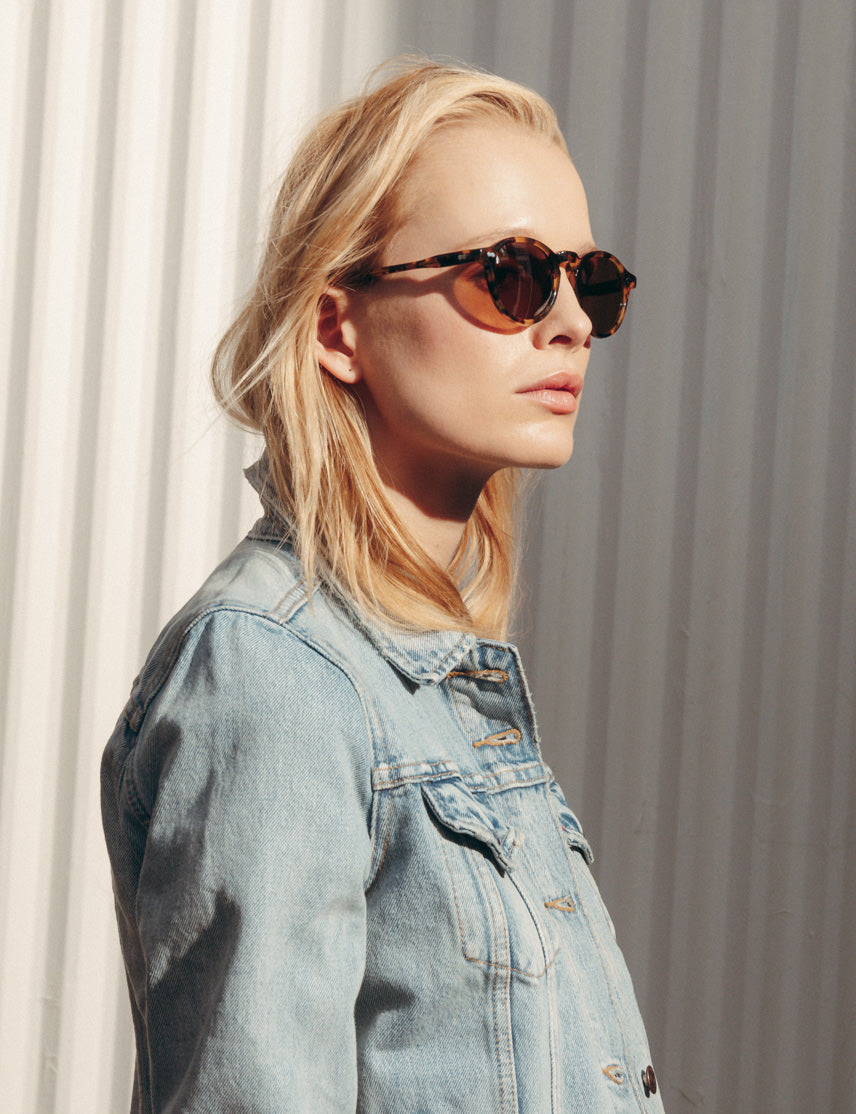 Model is wearing The MILTZEN SUN in Classic Havana in size 46 with Cosmitan Brown Glass Lenses