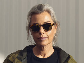 Model is wearing The MOMZA SUN in heritage/tortoise in size 46 with Calibar Green Glass Lenses
