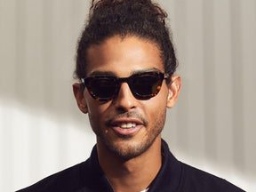 Model is wearing the TELENA SUN in tortoise/black in size 44 with Calibar Green Glass Lenses