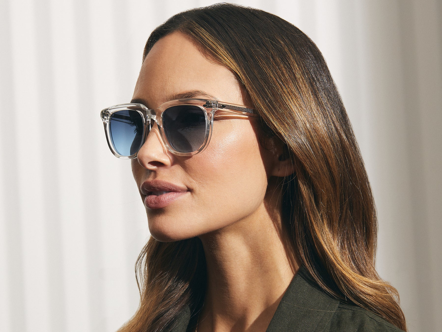 Model is wearing The YONTIF SUN in Crystal in size 52 with Denim Blue Tinted Lenses