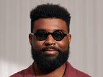 Model is wearing The ZOLMAN SUN in Black in size 42 with Blue Glass Lenses