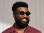 Model is wearing The ZOLMAN SUN in Black in size 42 with Blue Glass Lenses